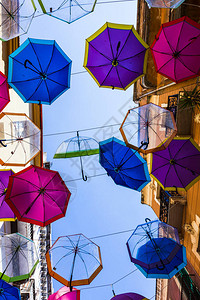 在撒丁岛小镇的一条街道上挂雨伞背景图片