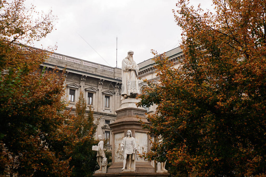在意大利米兰市历史古迹上建筑的秋树附近的LeonardoDaV图片