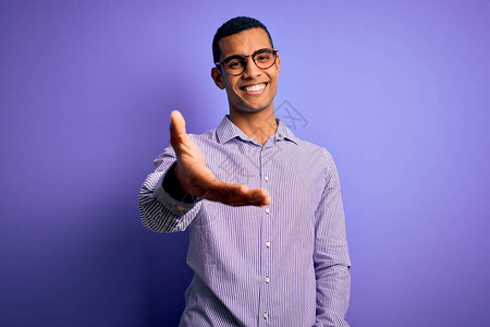 身穿条纹衬衫和眼镜的非洲帅哥男子在紫色背景上微笑着图片