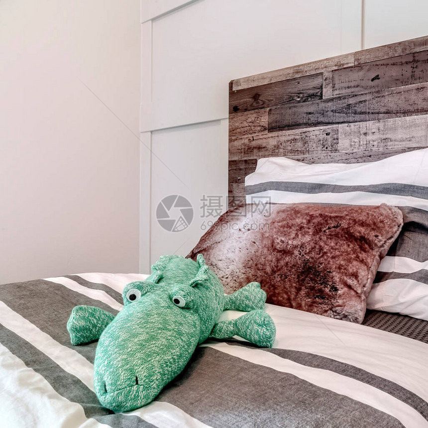 枕头和动物毛绒玩具放在带条纹床图片