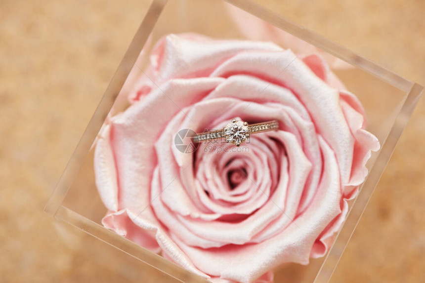 美丽的订婚戒指在粉红金属彩图片