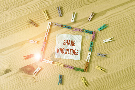 手写文本分享知识在展示彩色衣夹纸空提醒木地板背景办公室之间交换知识的图片