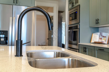 厨房岛水槽有双碗和黑色水龙头图片