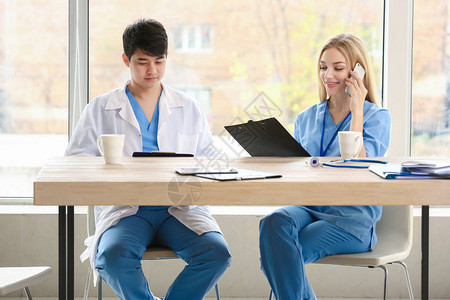 男医生和女医疗助理坐在图片