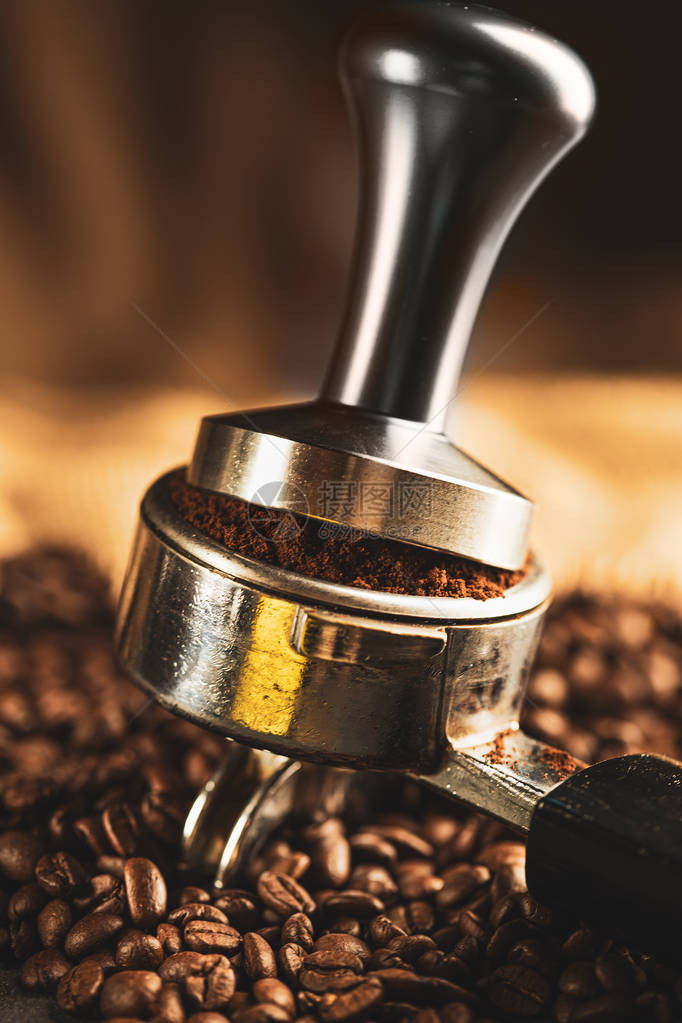 咖啡捣碎机咖啡压榨机由不锈钢和黑色背景咖啡烘焙机的烘焙咖啡豆制成图片