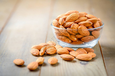 杏仁坚果在木桌上的玻璃碗中剥落杏仁是非常受欢迎的坚果和高蛋白图片