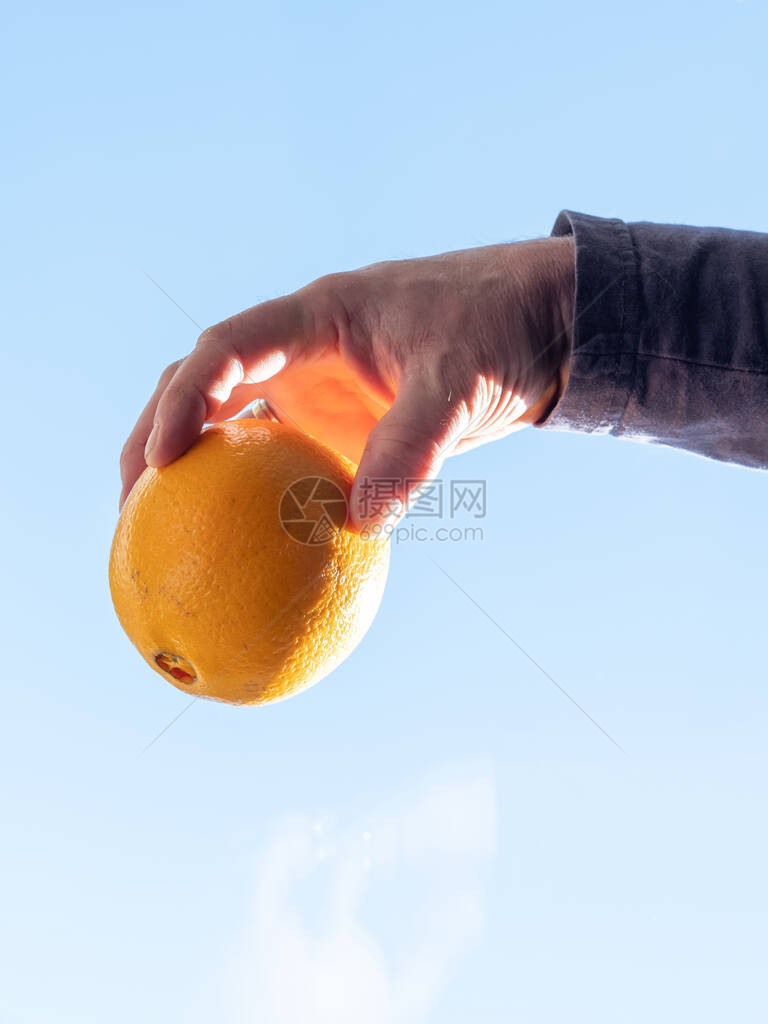 雄握着橙色的手男子戴着金戒图片