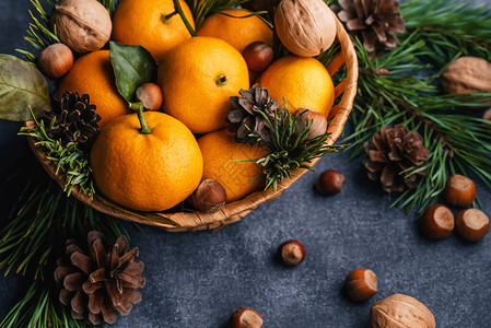 用松果和树枝装饰的橘子胡桃和栗子圣诞图片