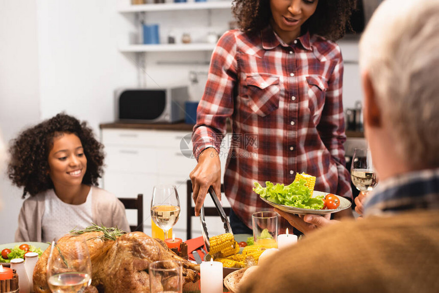 非洲裔美国妇女在与多元文化家庭一起庆祝感恩图片