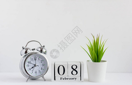 月8日在白色背景的木制日历上闹钟和日历图片