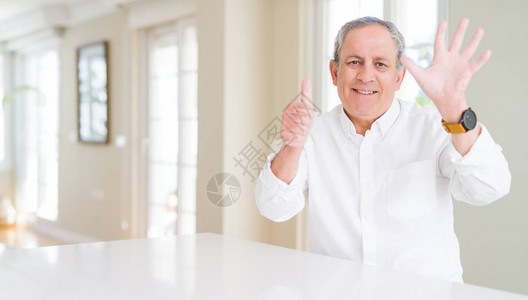 英俊的老人在家展出用六号手指举起6指头微笑自信图片