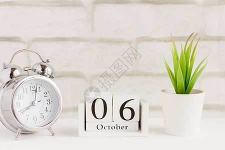 10月6日在闹钟旁边的木日历上背景图片
