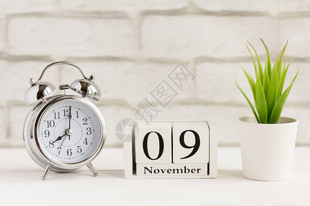 11月9日在闹钟旁边的木日历上背景图片