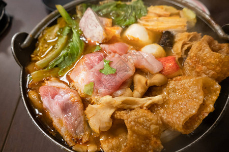 小火锅配蔬菜和肉在餐厅背景图片