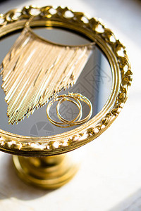 金耳环和项链在镜盘上装饰框架的图片