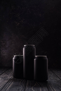 深色木桌上的黑色啤酒罐图片