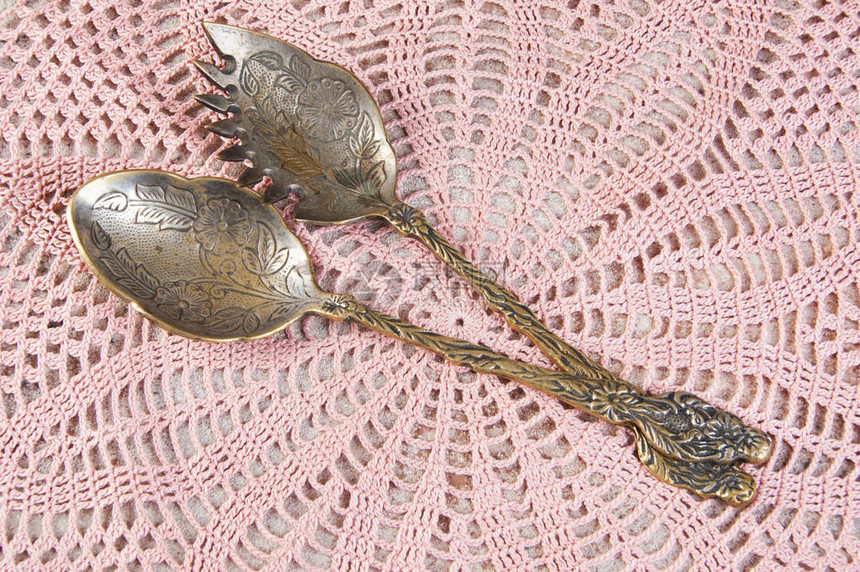 两勺古董黄铜沙拉汤匙放在编织圈上食物摄影道具和图片
