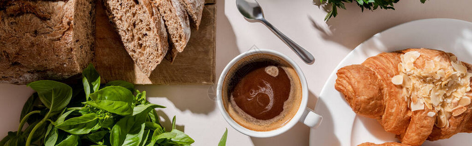 灰色桌上新鲜羊角面包面包面包和咖啡及早餐咖啡的顶端视图片