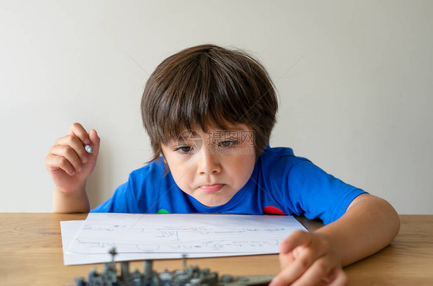 肖像小孩在战舰上绘画童子玩模拟船玩具和纸面草图室内活动概念家庭教育图片