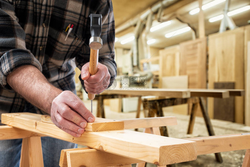 特写木匠用锤子和钉子固定木板建筑图片
