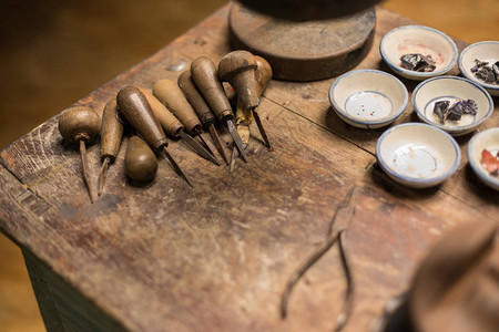旧木桌上的古代雕刻工具图片