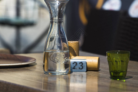 餐桌上有一瓶水一杯玻璃和一张背景图片