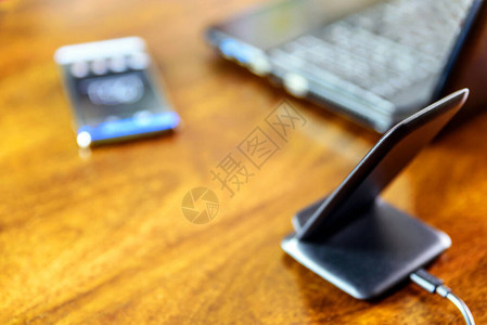 无线电话通过智能手机和膝上型电脑在家庭办公室的办公图片
