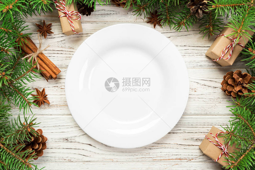 上方视图木制圣诞节背景的空板圆陶瓷假日晚餐菜式概念图片