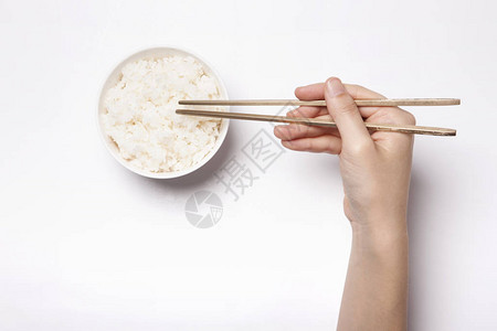 女人手拿着筷子白桌上放着米饭图片