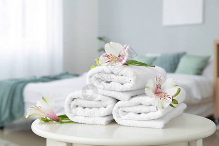 干净柔软的毛巾桌上放着鲜花图片
