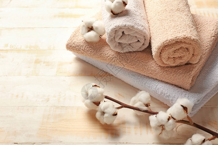 木制背景上的棉花和柔软的毛巾图片