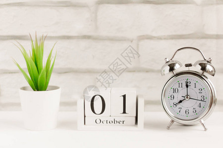 10月1日在敲闹钟旁边的木制日历上新背景图片