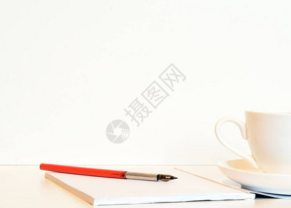 白色背景上是一本带复古笔的记本靠近一杯咖啡音乐会茶歇商务会图片