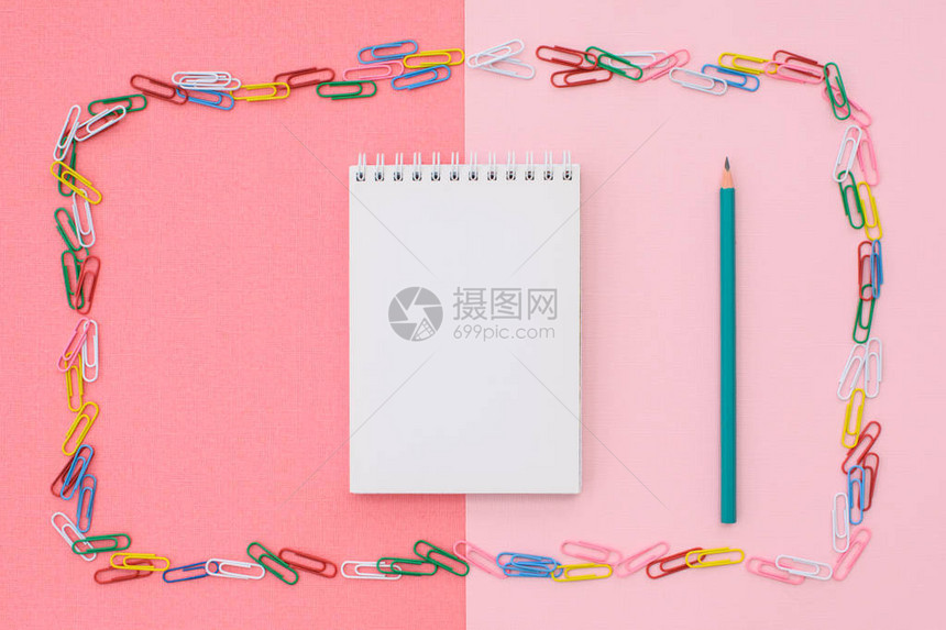 笔记本上写着绿色铅笔在双背景的彩色纸片框里粉红色和珊瑚概念图片
