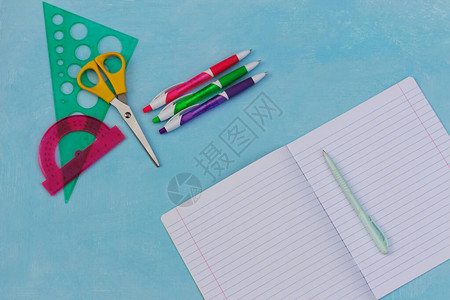 蓝漆背景的开放笔记本和多彩学校用品返回学校概念学年开始您可参加图片