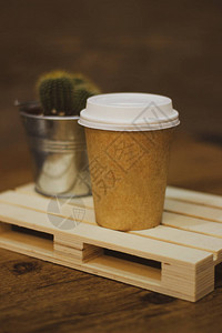 棕色咖啡杯带有仙人掌和木托盘底图片
