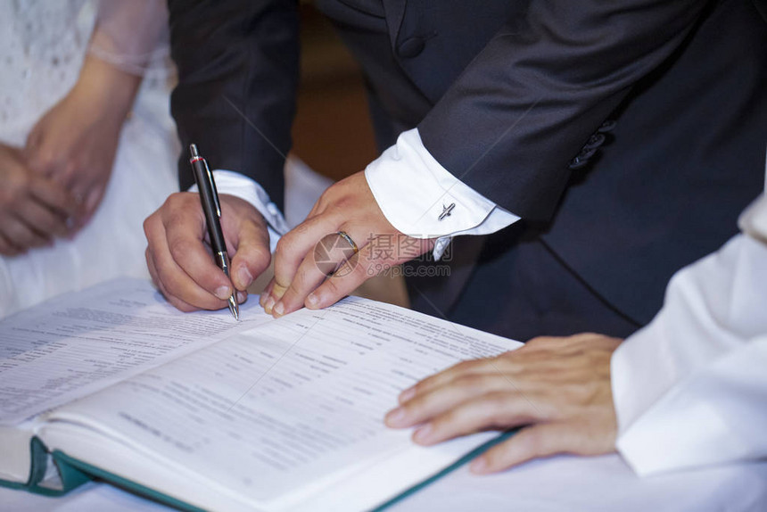 新郎在婚姻手中签署结婚契约