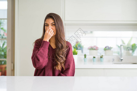 年轻漂亮的女人在家里闻到一些难闻的令人作呕的难以忍受的气味图片