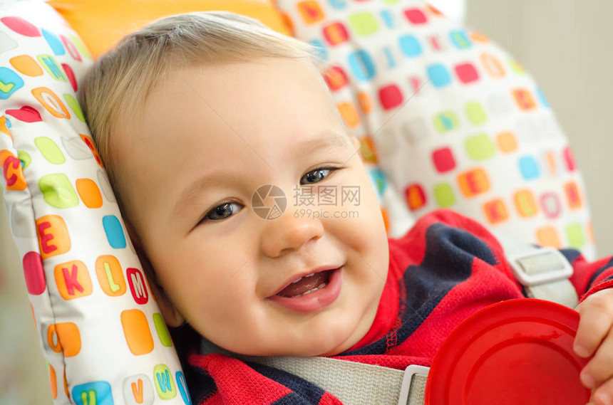 坐在高脚椅上微笑的男婴图片