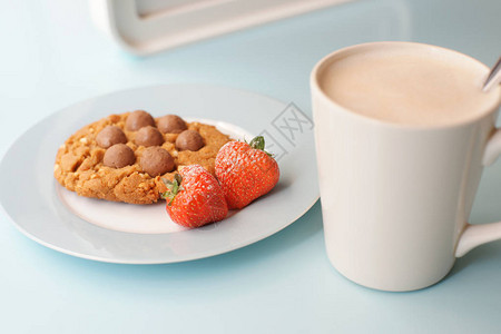 一杯咖啡和饼干配巧克力和草莓图片