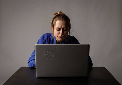蓝衣年轻女子用笔记本电脑上网图片