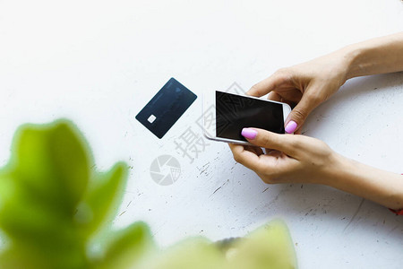 女手持信用卡和智能手机图片