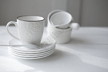 白色茶杯盘子和餐具放在架子上最起码的风格餐具时尚无缝厨房优雅的图片