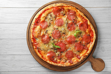 木板上的美味意大利辣香肠比萨图片