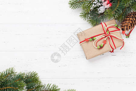 圣诞贺卡与礼品盒和枞树枝在木纹理背景圣诞背景带有复制空间的顶视图片
