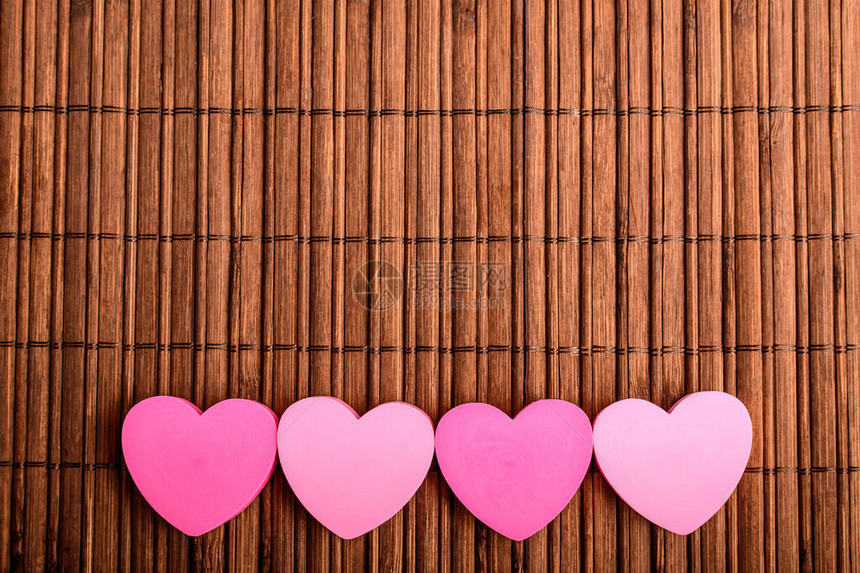 棕竹桌装饰上带有四个粉红心的直线图片