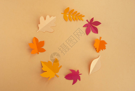 秋季作文框架由橙色背景上的装饰纸叶制成贺卡图片