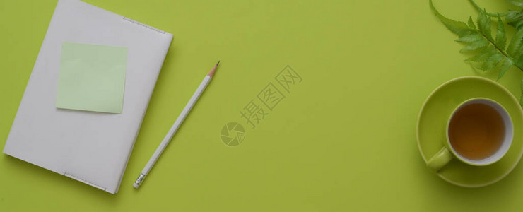 绿色桌背景上有日记笔本茶杯装饰和复制空间的创造工作图片