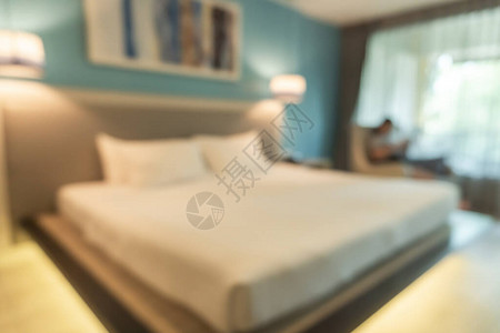 酒店卧室模糊背景客房内部配有模糊舒适的特大号床白色床单办公图片