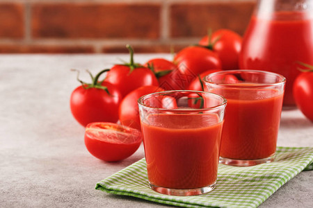 一杯美味的番茄汁和成熟的红番茄背景图片